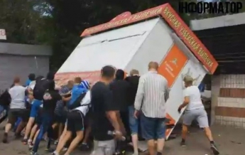 В Киеве люди в масках перекинули киоск (видео)