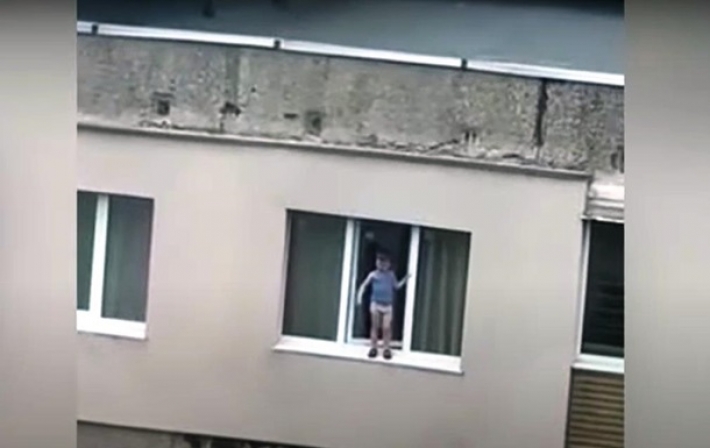 В Мариуполе ребенок стоял на подоконнике 9 этажа: момент попал на видео