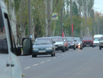 Автомобиль с красными флагами разъезжает по городу (видео)