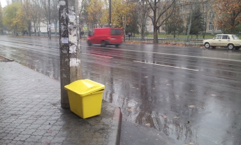 На центральных улицах уже расставили желтые контейнеры для посыпки тротуаров (фото)