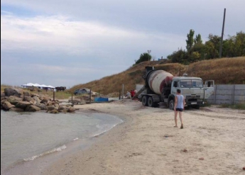 Владельцы базы отдыха выстраивают бетонный забор на берегу (фото)