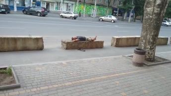 В центре города на заградительных блоках мужчина устроил ночлежку (фото)
