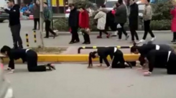 В Китае провинившихся офисных работниц заставили ползти на четвереньках по улице (видео)