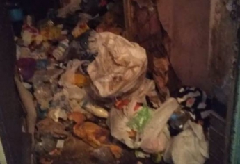 Житель Запорожья спит в подъезде, забив свою квартиру мусором (Фото)
