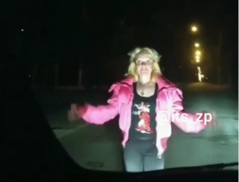 Невменяемая женщина в розовой курточке "преследовала" авто (Видео)