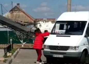В Мелитополе неадекватная женщина крушила маршрутки на остановке (видео)
