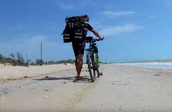 Видео дня: мужчина путешествует на велосипеде вдоль берега моря (видео)