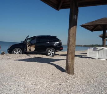 "Славно отдохнули": на запорожском курорте внедорожник застрял на пляже в окружении бутылок
