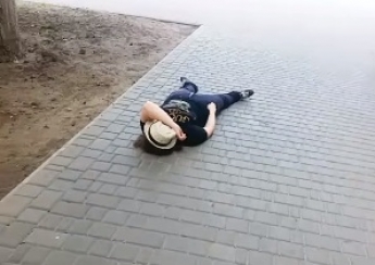Девушка в центре города разлеглась на тротуаре (видео)