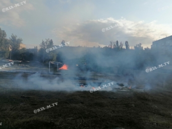 Жители окрестных домов пытаются потушить пожар на футбольном поле (фото)