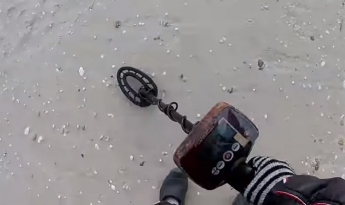 На пляже в Кирилловке копатели нашли оружие и иностранную валюту (видео)