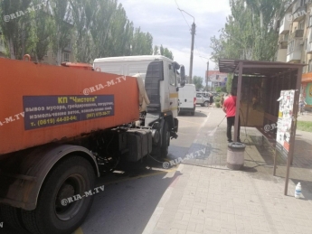 В Мелитополе коммунальщики вымыли остановки, которые загадил бродяга (фото, видео)