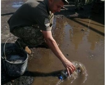 В Луцке военные бутылками выгребали воду из луж на дороге, по которой поедет Зеленский: фото