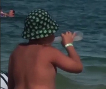 В Кирилловке ребенок с одобрения мамы пил слабоалкоголку, а потом резвился в море (видео)