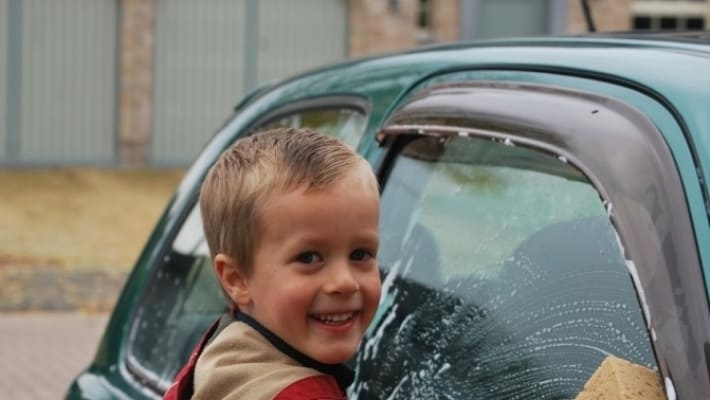 В Мелитополе ребенок моет на парковке автомобили, чтобы помочь родителям