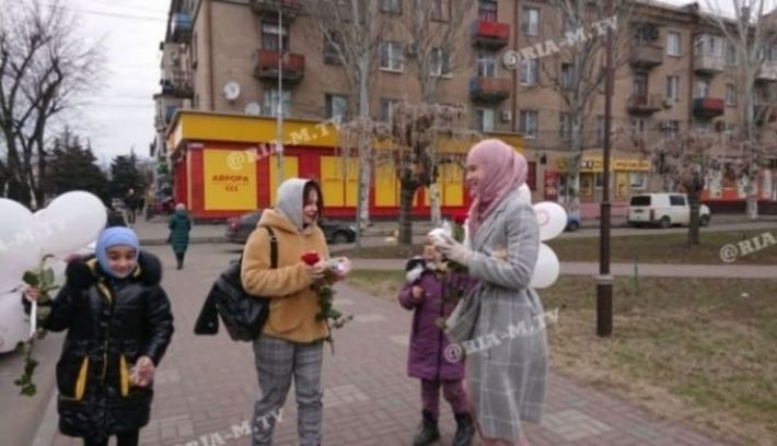 В Мелитополе в центре города женщины в хиджабах раздают цветы и сладости (видео)