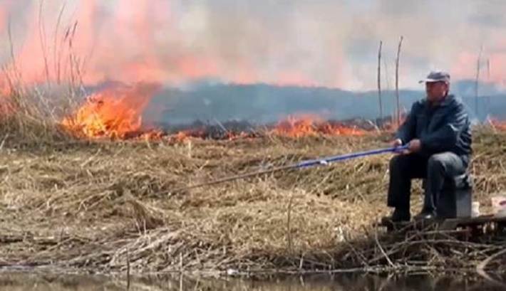 И пусть весь мир подождет: в Беларуси мужчина рыбачил в кольце огня - видео