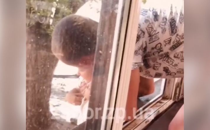 В Запорожье горе-отец "под градусом" едва не выронил ребенка из окна (видео)